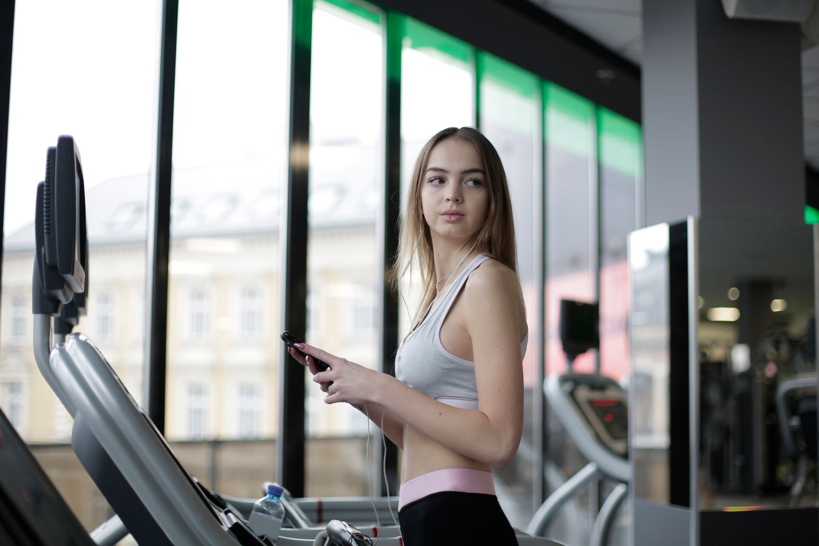 Een sporter met haar telefoon in de club