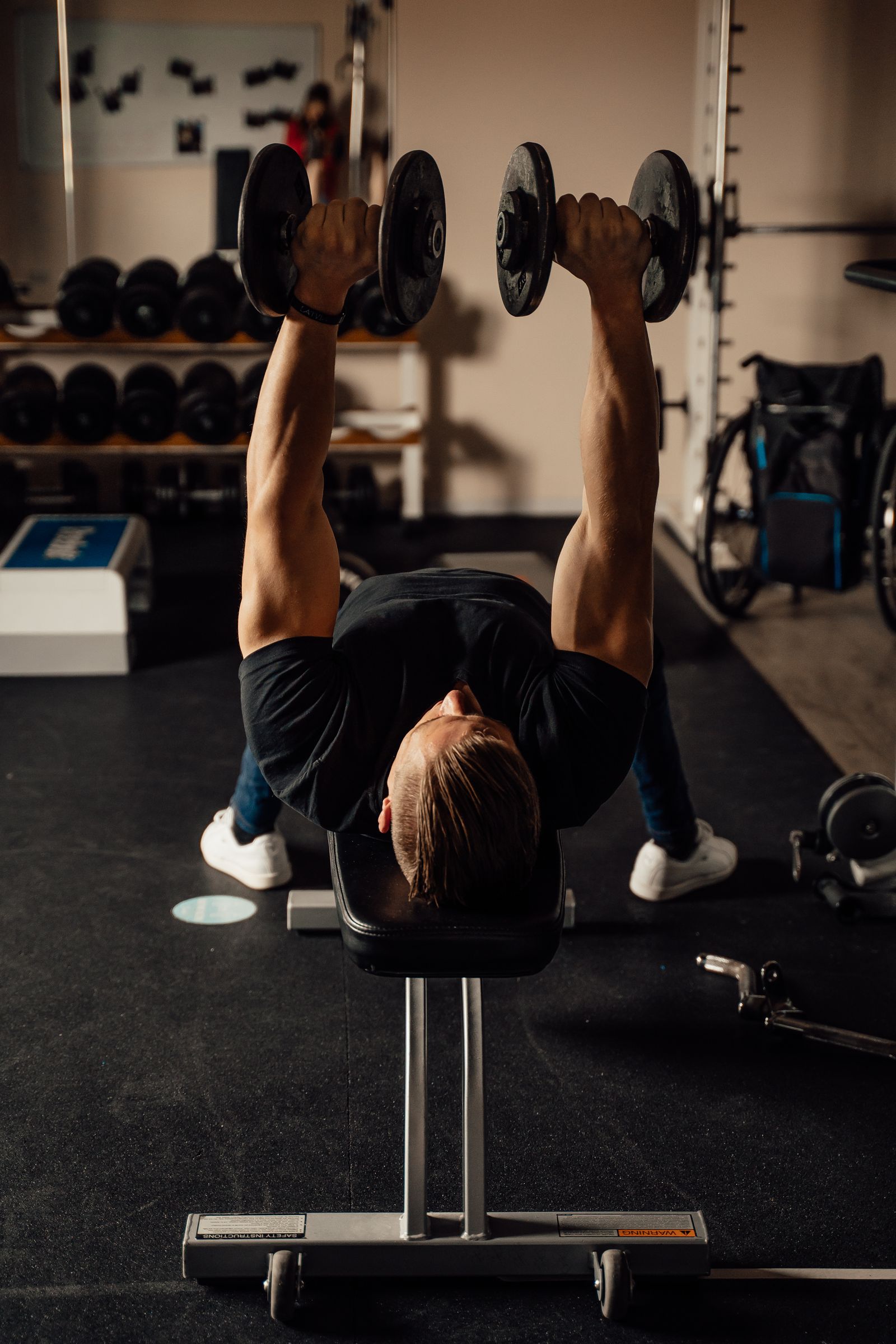 Een sporter traint met dumbbells