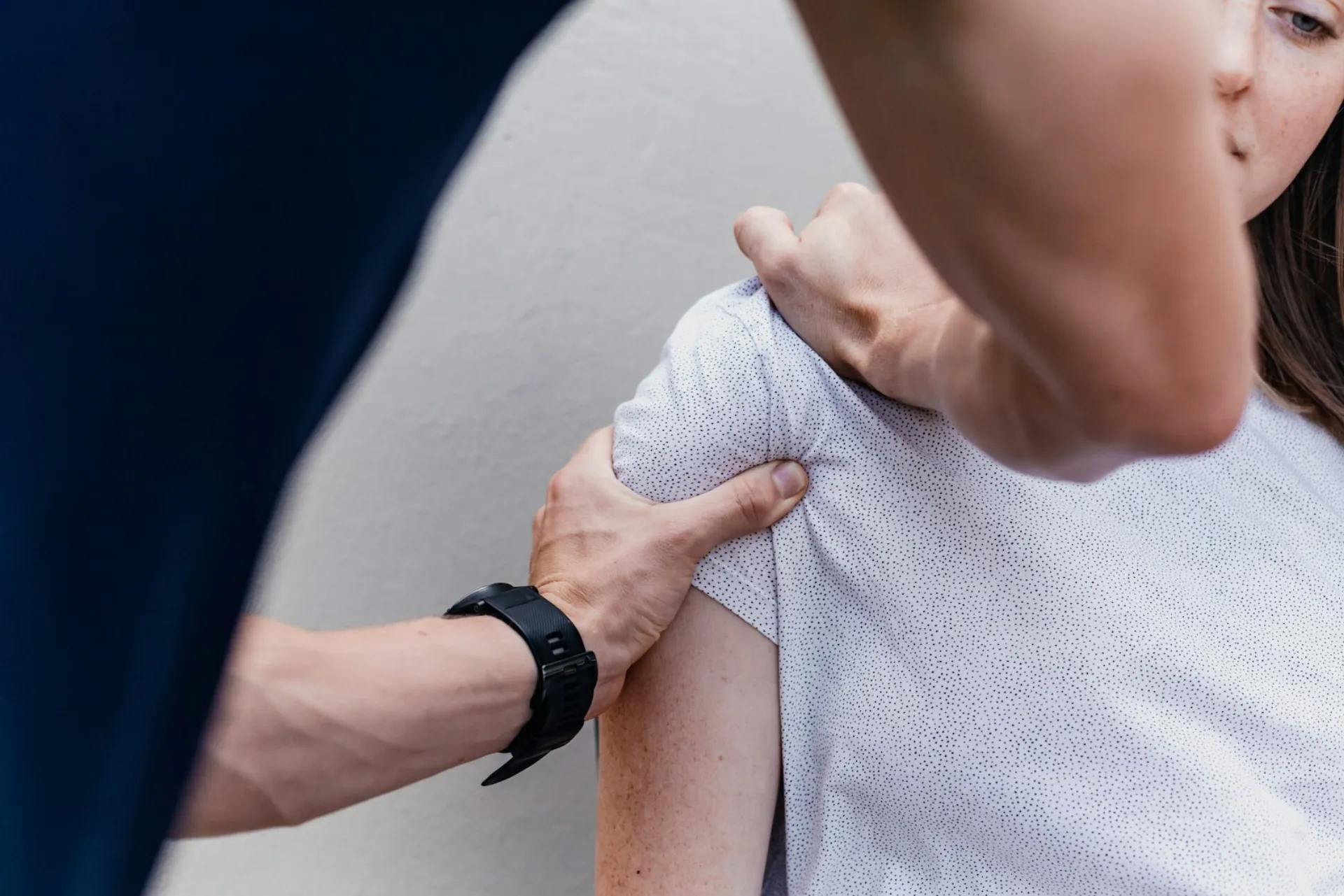 Een therapeut beoordeelt de schouder van een cliënt