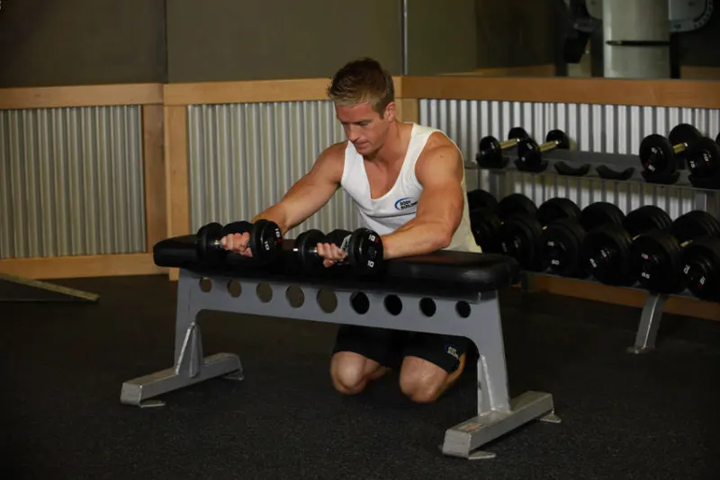 Reverse wrist curl met dumbbells op een bank, eindpositie