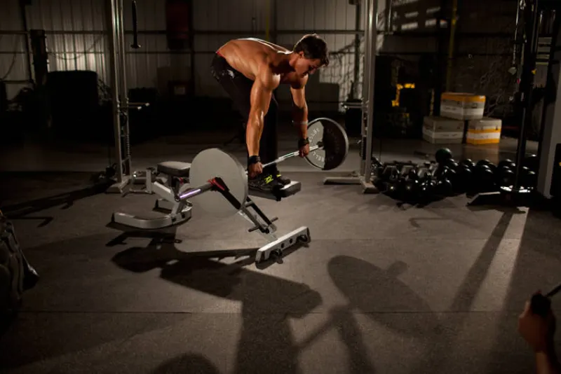 Roeien met barbell vanaf de bank
