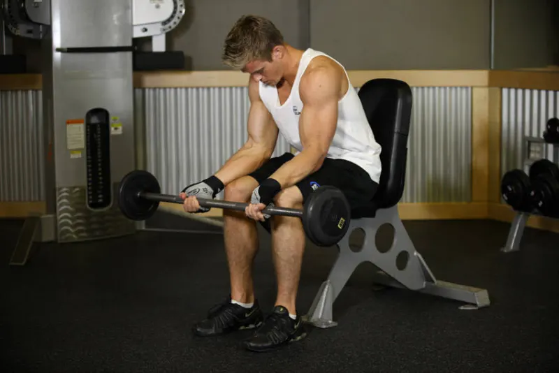 Wrist curl met barbell zittend op je bovenbenen